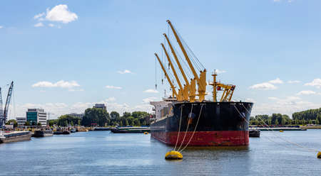 Logistics business, Ship with cranes anchored at international commercial port of Rotterdam, Netherlands. sunny summer dayの写真素材