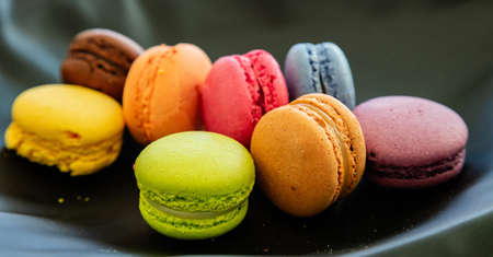 Macarons pastel colors with chocolate cream on black background, close up view with details, bannerの写真素材