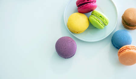 Macarons pastel colors with chocolate cream on white background, top view, copy space