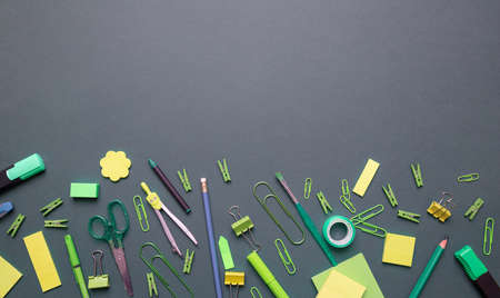 School supplies green and yellow color on gray background, top view, copy space. Back to school...