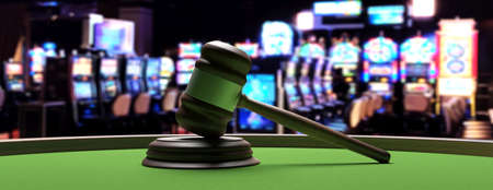 Casino and law concept. Judge gavel on green felt roulette table, blur slot machines room background, banner. 3d illustrationの写真素材
