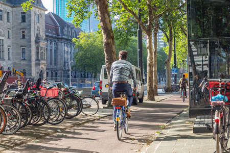 Rotterdam, Netherlands. June 27, 2019. Back view of people riding bikes in the city center, Spring sunny dayのeditorial素材