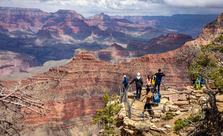 Grand Canyon, Arizona, USA. May 23, 2019. Group of people taking photos and looking at the red rocks gorge, cloudy skyのeditorial素材