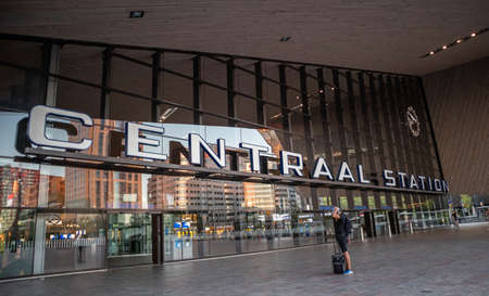Rotterdam Netherlands, June 30, 2019. Rotterdam Centraal, Central station building facade and entrance. Young man with luggage waiting.のeditorial素材