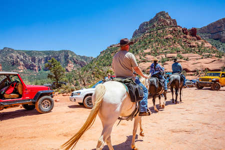 Sedona Arizona USA. May 25, 2019. People riding horses and 4X4 parked on terrain. Red orange desert  landscape, clear blue sky, sunny spring dayのeditorial素材