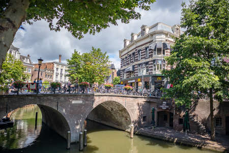 Utrecht, Netherlands - JULY 01, 2019: Stone bridge above river with bikes and unrecognizable people near beautiful buildings in old townのeditorial素材