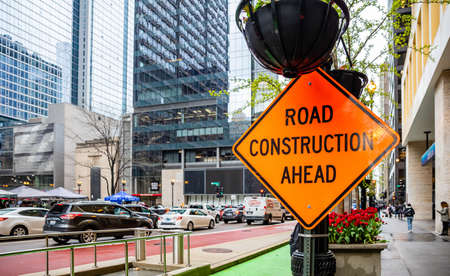 Chicago, Illinois, US. May 9, 2019: Road works. Road construction ahead text, road warning sign orange color in the city centerのeditorial素材