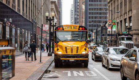Chicago, Illinois, US. May 9, 2019: Back to school. School bus yellow color on the road, city center, spring morningのeditorial素材