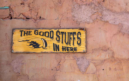 Calico ghost town California, USA. May 29, 2019. The good stuffs in here text on a yellow wood sign, faded wall backgroundのeditorial素材