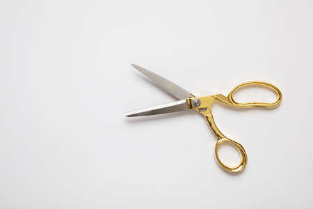 Scissors open gold and silver color isolated against white background, copy space, top view. Tailor,...