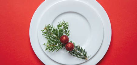New year, xmas dinner table setting. Fir tree twig on white set of dishes isolated, red color...