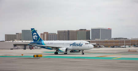 Los Angeles airport, USA. June 2, 2019. Alaska airlines plane on airfield, cloudy sky.