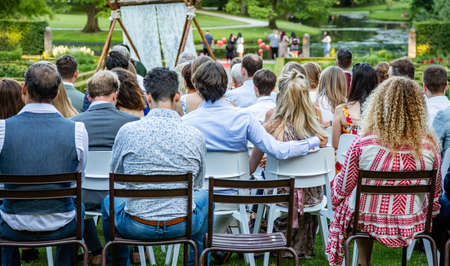 Rotterdam, Netherlands. June 29, 2019. Ijsvrij festival in a park. People are sitting, waiting for a ceremony to be start. Rear view, blur nature background.のeditorial素材
