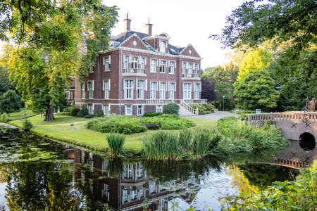 Rotterdam, Netherlands. June 29, 2019. Villa Jamin surrounded by nature. A peaceful river flowing under a bridge. Destination for vacation.のeditorial素材