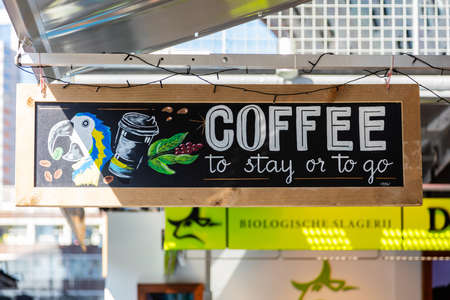 Rotterdam, Netherlands. June 28, 2019. Coffee to stay or to go. Hanging board advertise a coffee shop.のeditorial素材