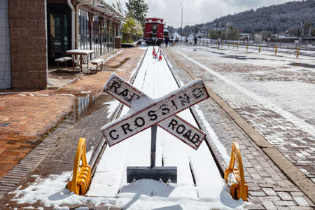 Williams Arizona USA. May 23, 2019.  Williams train station. Rail road crossing sign and train tracks covered with snowのeditorial素材