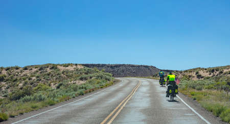 Arizona countryside, USA. May 25, 2019: Rear view of cyclists biking near petrified forest, blue clear sky, sunny spring dayのeditorial素材