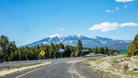 Arizona highway, USA. May 26, 2019: Highway near Flagstaff, snow on the mountains, blue sky, sunny spring dayのeditorial素材