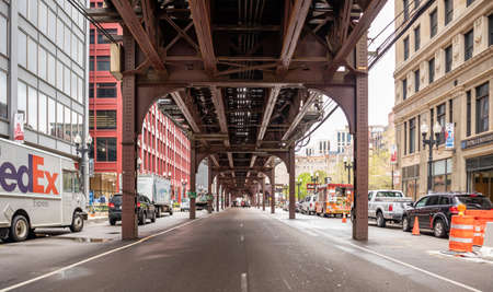 Chicago, Illinois, USA, May 9, 2019. Traffic at street under and next to a metal bridge with columns. Transportation at city background.のeditorial素材