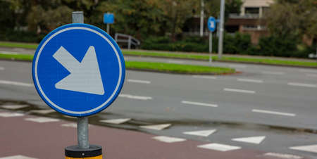This way roadsign. Road sign one way, blue and round, white color arrow pointing direction right and...