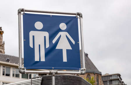 WC toilets sign. Mobile toilets signage in the city for an outdoors event, cloudy sky background....