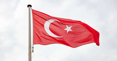 Turkey flag. Turkish national sign and symbol waving on a flagpole against cloudy sky background