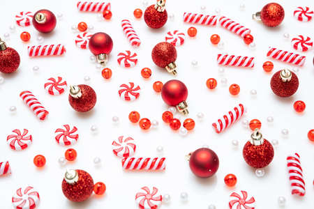 Christmas decoration. Xmas candies red and white color and red balls against white background, top viewの写真素材