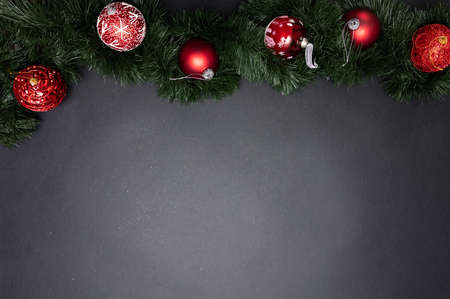 Christmas decoration. Xmas balls red color and fir twig against dark gray background, copy space,...