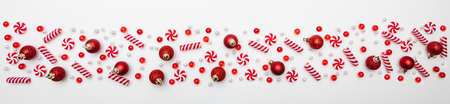 Christmas decoration. Xmas candies red and white color  against white background, top view, bannerの写真素材