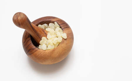 Mastic resin tears. Chios mastic in a wooden mortar isolated on white backgroundの写真素材