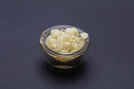 Mastic resin tears. Chios mastic in a glass bowl isolated on black backgroundの写真素材