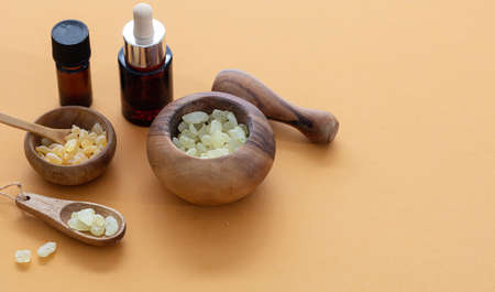 Mastic resin tears. Chios mastic in wooden bowls and essential oil on orange color backgroundの写真素材