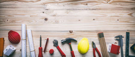 Construction, house renovation concept. Hand tools, hard hats and project blueprints on wood, copy...