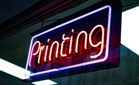 St Louis, USA. May 12, 2019. Printing Neon Sign. Electric red letters on glass board advertise the store. Close up view with details.のeditorial素材