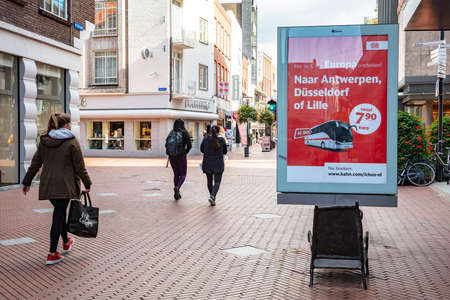 Eindhoven, Netherlands October 10, 2019. People walking on a pedestrian steet in the city center. Big advertising panel and shops, autumn cloudy dayのeditorial素材