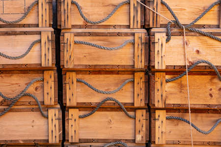 Crates boxes wood with ropes as handle in columns, full background texture. Stacked crates for storage and transportation.の写真素材