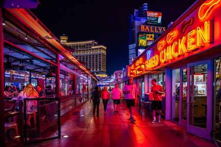 Las Vegas, Nevada, USA. May 28, 2019. Nightlife at city with illuminated cafe, restaurant and neon signs. Urban scene with pedestrians who look for entertainment events.のeditorial素材