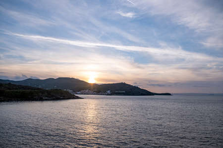 Sunset over Aegean sea, blue orange color sky with clouds background, Kea island, Korissia port, Greece.の写真素材