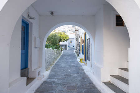 Traditional greek whitewashed buildings, cobblestone streets and stone structure arch in Ioulida village, Chora.の写真素材
