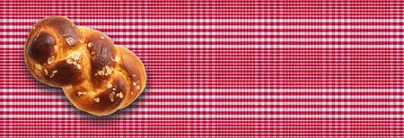 Sweet bread, easter tsoureki, cozonac on red checkered tablecloth background. Braided brioche, festive traditional challah. Banner, copy spaceの写真素材