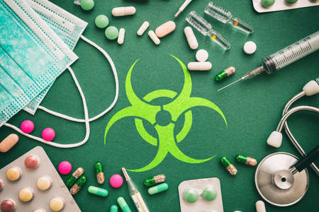 Virus flat lay, therapy concept. Virus sign on green background with madicine and medical tools, top viewの写真素材