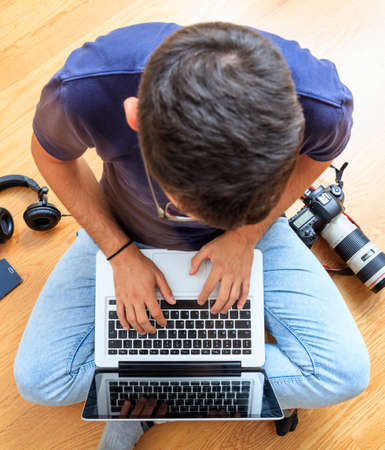 Home office, remote work. Young man working with a computer laptop. Telecommute, teleworking, work from home, making use of the Internet, email, and telephone.の写真素材