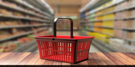 Supermarket, food, groceries shopping concept. Red empty shopping basket against blur food market...