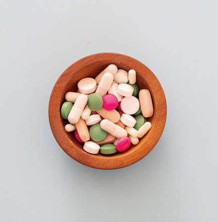 Medicine pills, tablets and capsules on blue pastel background. Colorful variation of pharmacy products, above view. Medical treatment, health conceptの写真素材