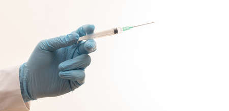 Medicine vaccination. Doctor hand injecting vaccine with syringe isolated against white backgrounsd, closeup. Health care in hospital concept.の写真素材