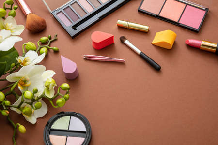 Makeup natural cosmetic products against brown color background. Make up female accessories, flat lay, top view, copy spaceの写真素材