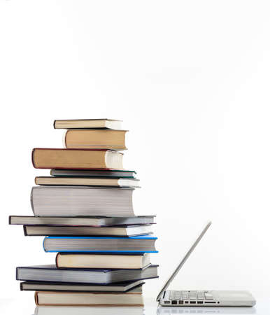 E learning concept. Books stack and an open computer laptop isolated on white background. Distance...