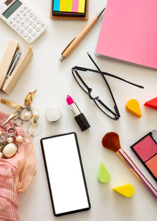 Woman accessories and smartphone with blank white screen against white color background, flat lay, top view. Fashion blogger workspace, copy spaceの写真素材