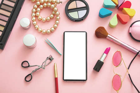Woman accessories and smartphone with blank white screen against pink color background, flat lay, top view. Fashion blogger workspace, copy spaceの写真素材