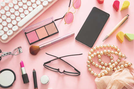 Fashion blogger workspace with computer laptop and woman accessories. Female products against pink color background, flat lay, top view.のeditorial素材